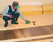 Põrandalaudade paigaldamine tuulutatavale soojustatud põrandale – aurutõkkekile alla jäävad soojustus, puidukaitse­vahendiga immutatud talad ja tuuletõkkeplaat. Foto: Saint-Gobain Isover Eesti AS