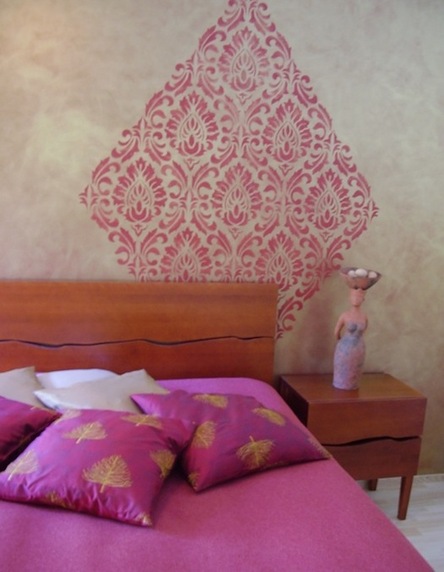 Efektvärviga maalitud magamistoa seina ilmestab šablooniga peale maalitud eksootiline muster.
